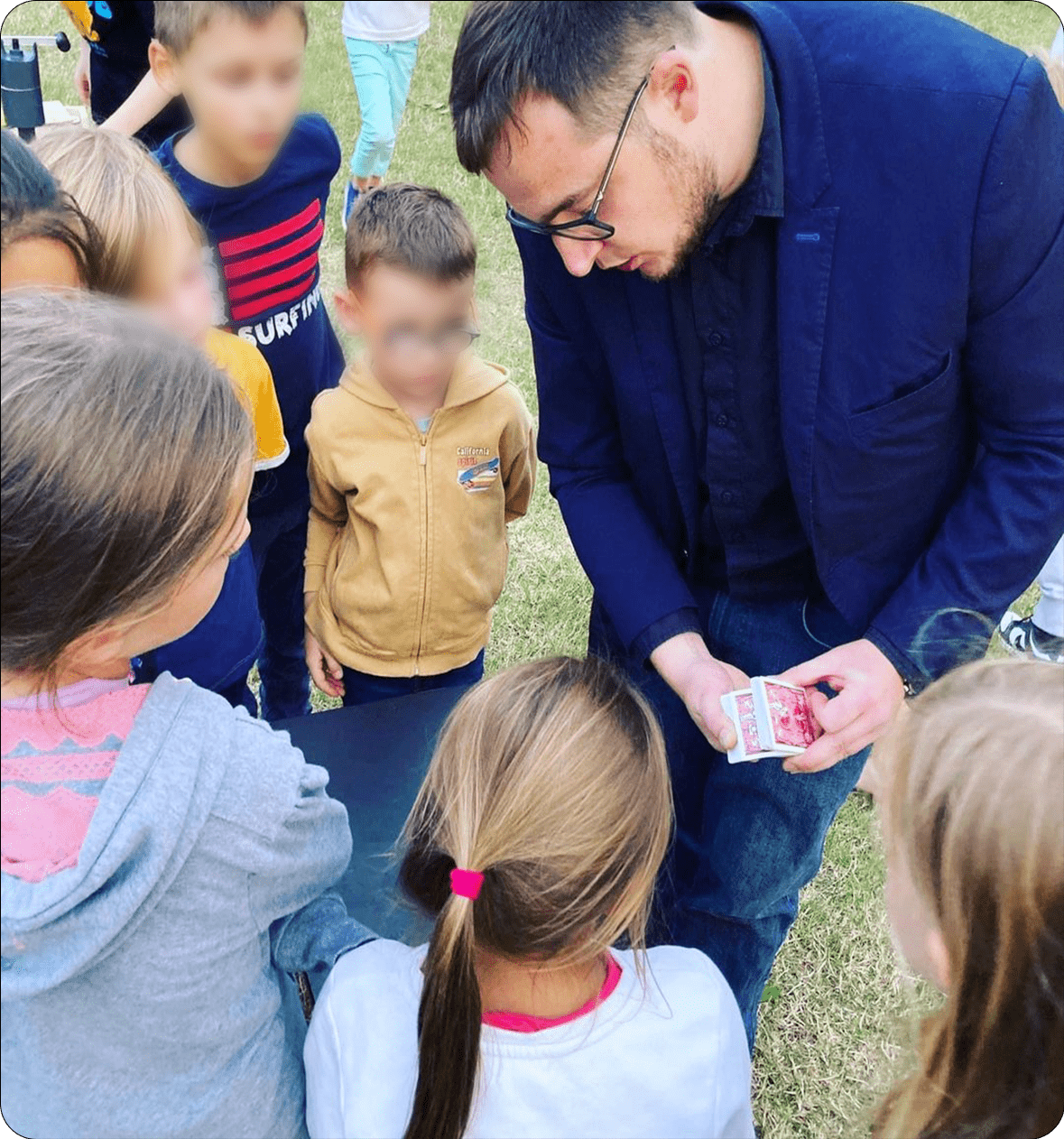 Le magicien Nicolas Proville faisant un tour de magie à un groupe d'enfants lors d'un événement organisé par Extra EVENTS.