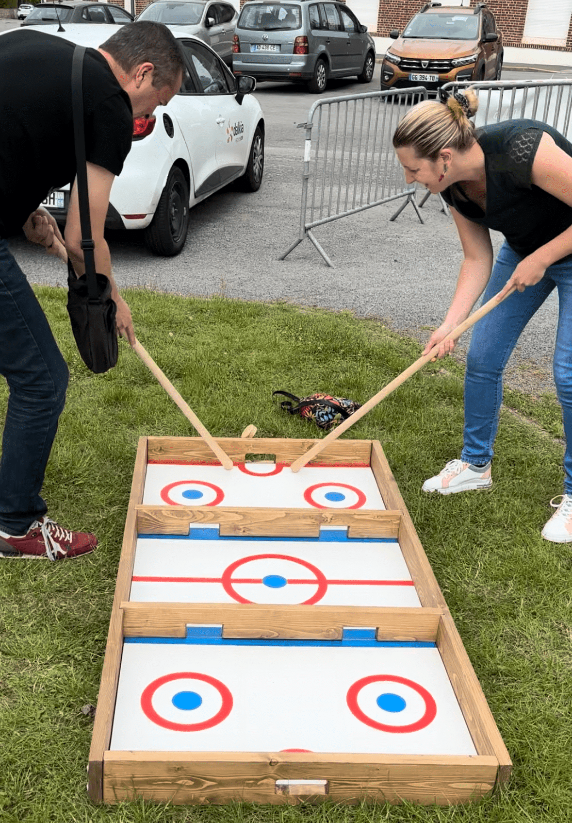 Box Hockey, un jeu compétitif où deux joueurs utilisent des crosses pour marquer des buts dans un cadre en bois.