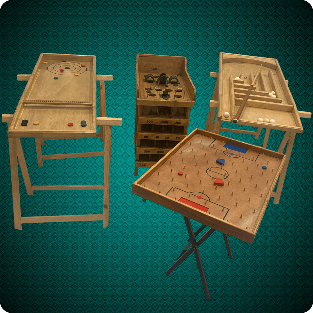 Photo de quatre jeux traditionnels en bois, incluant l'Aérobille, la Pétanque de table, le jeu de la Grenouille, et le Pichenette Battle, sur un fond décoratif vert.